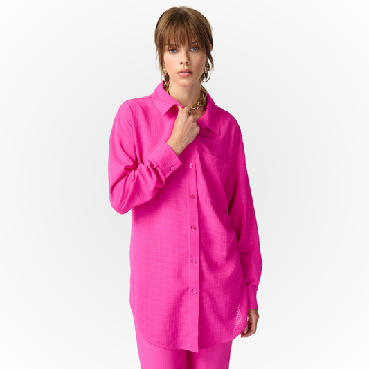 Jaboli Boutique - Fergus Ontario - Joseph Ribkoff Shirt  241259. Joseph Ribkoff Shirt 241259 in a charming shade of pretty pink. Versatile wardrobe essential for use as a cover-up, jacket, or stylish top. Crafted from textured fabric with a classic collar and button front. Long sleeves and tunic length with a sculpted hemline for comfort and sophistication. Ideal for on-the-go or getaway, serving as the perfect travel companion. Proudly made in Canada, reflecting a commitment to quality craftsmanship. 