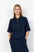 Woman wearing a navy blue dress with a zipper on a white background