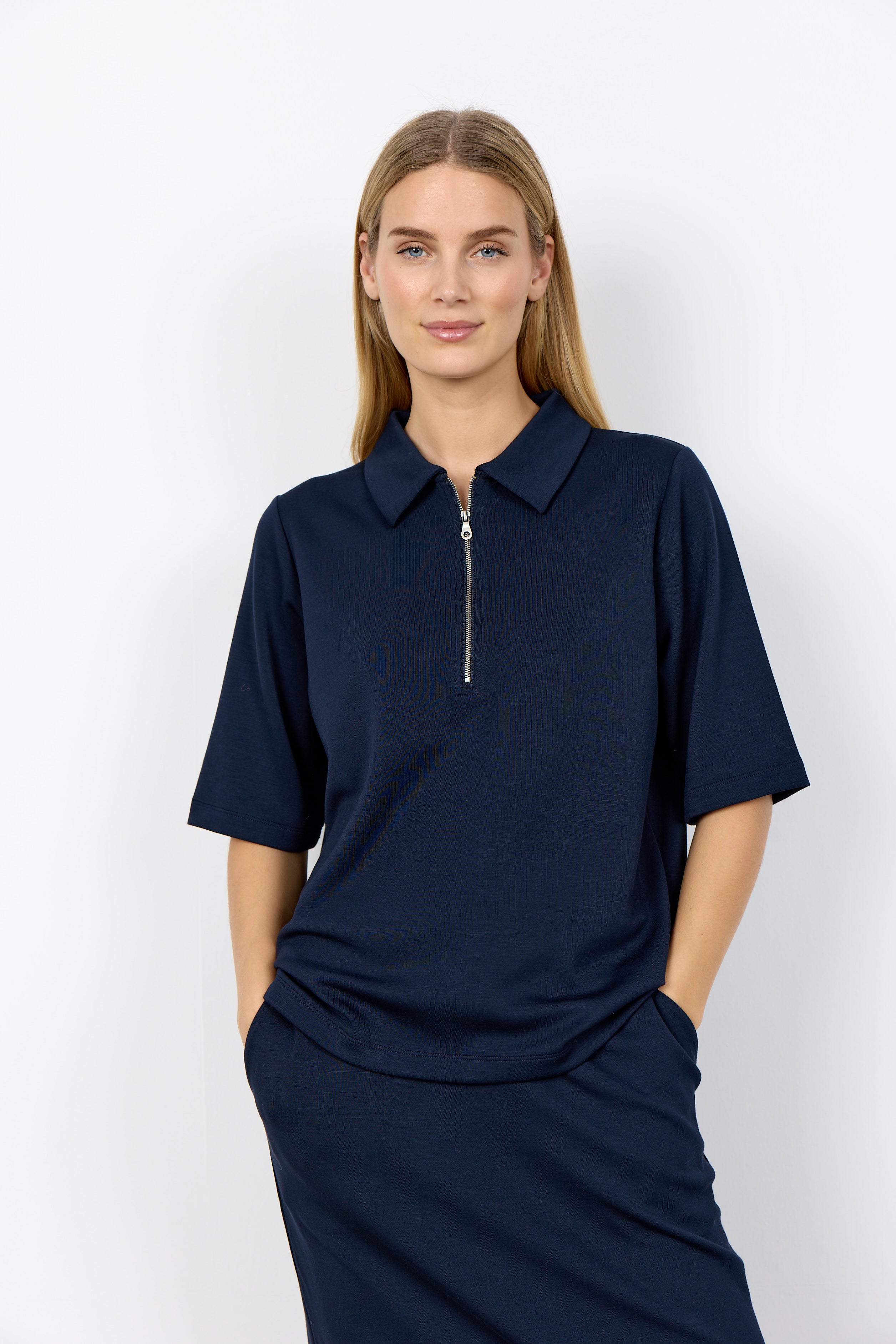 Woman wearing a navy blue dress with a zipper on a white background