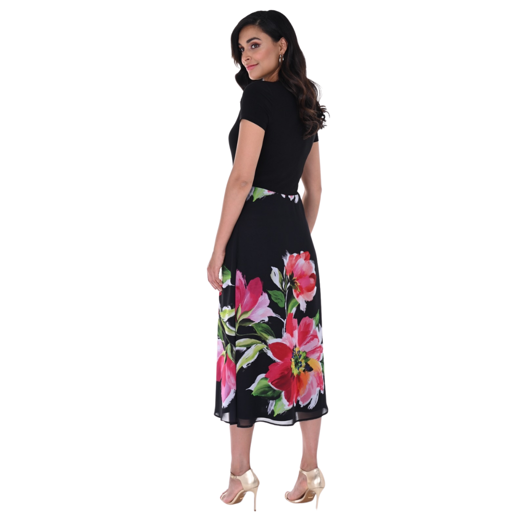 Jaboli Boutique - Fergus Ontario - Frank Lyman Black/Fuchsia Dress: Effortlessly blends elegance with a bold flair Playful sophistication: Short-sleeve design and classic crew neck Vibrant colors: Adorned with a floral placement print in fuchsia and green Timeless ensemble: Tea-length cut and flowy skirt with chiffon overlay Proudly crafted in Canada: Perfect balance of style and quality Standout for any occasion: A stunning and versatile choice!