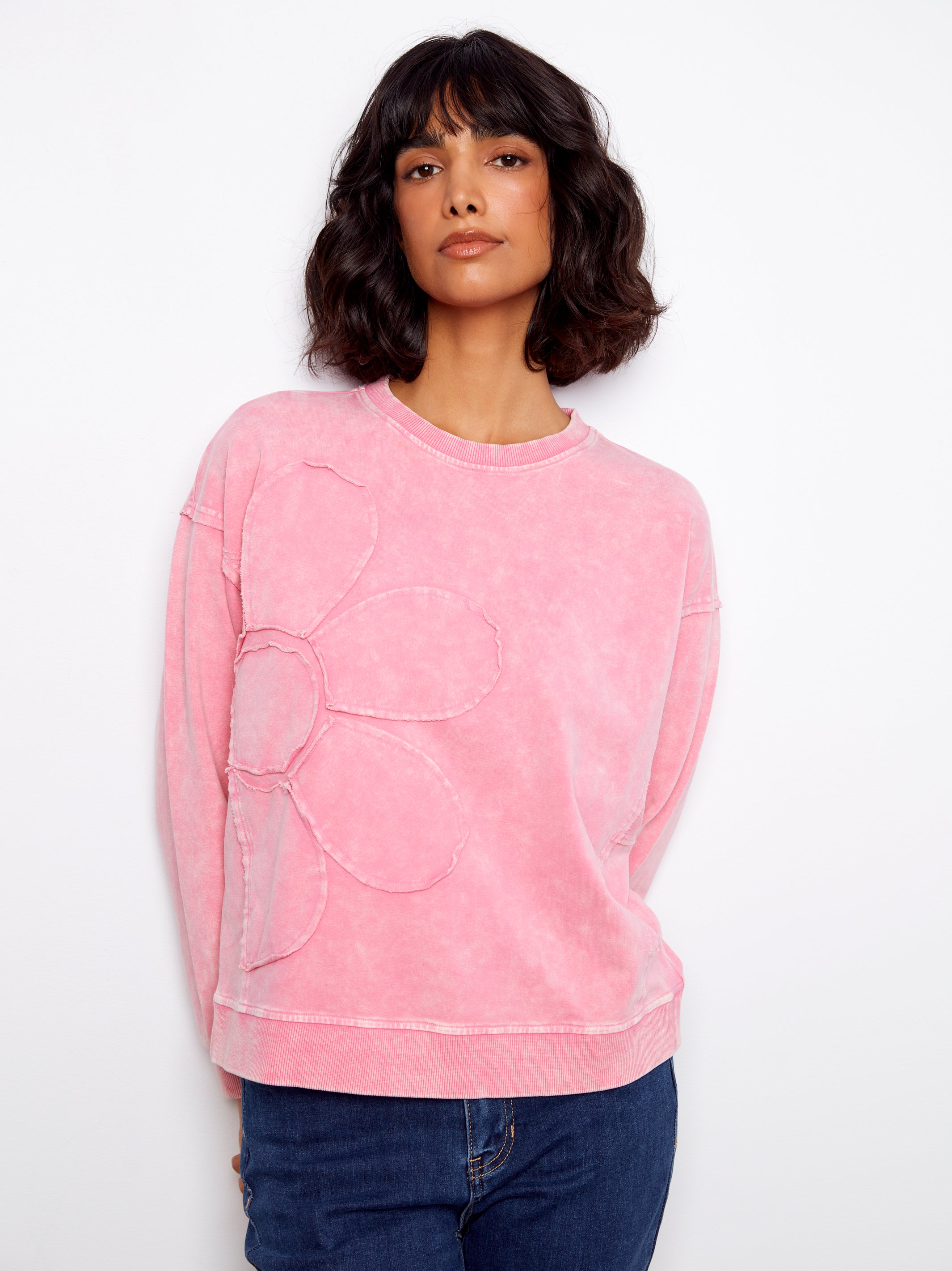 Woman wearing a pink sweatshirt with a white background