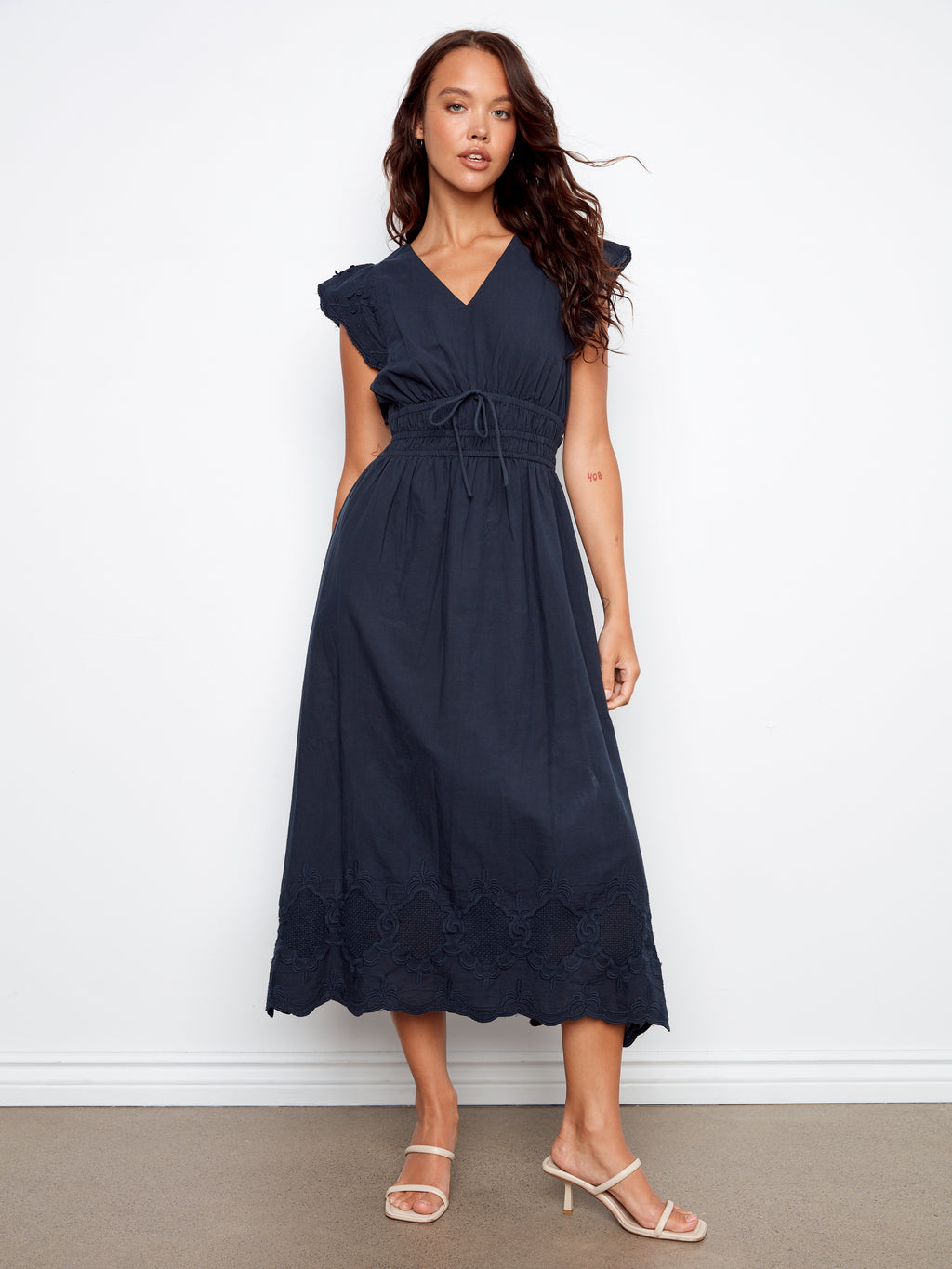 Woman wearing a navy blue dress against a white background