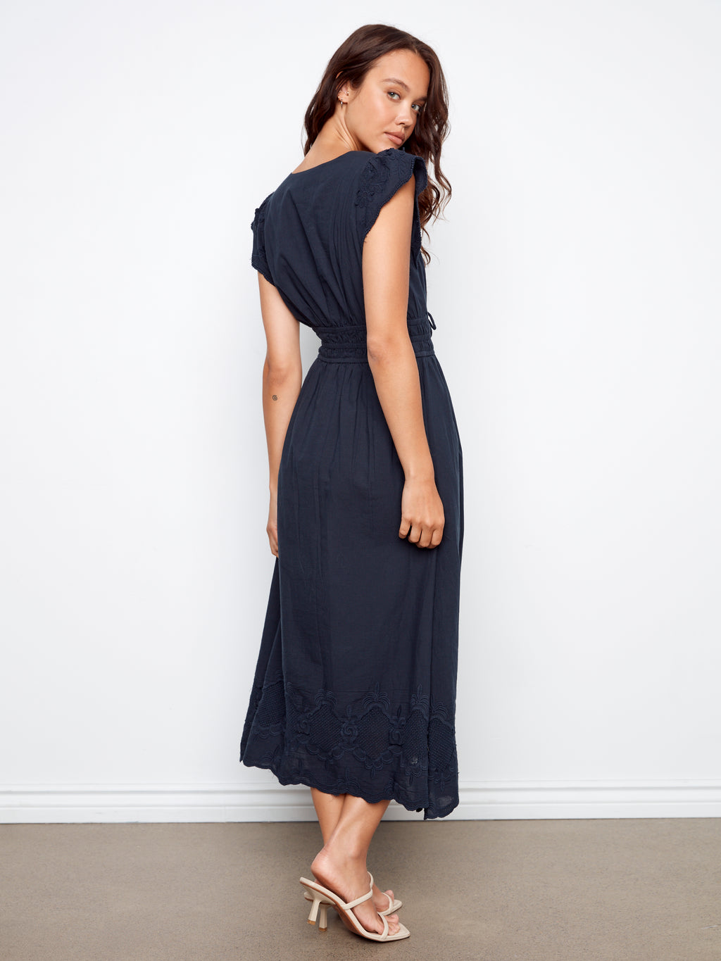 Woman wearing a navy blue dress against a white background