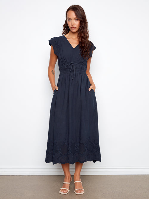 Woman wearing a navy blue dress against a white background