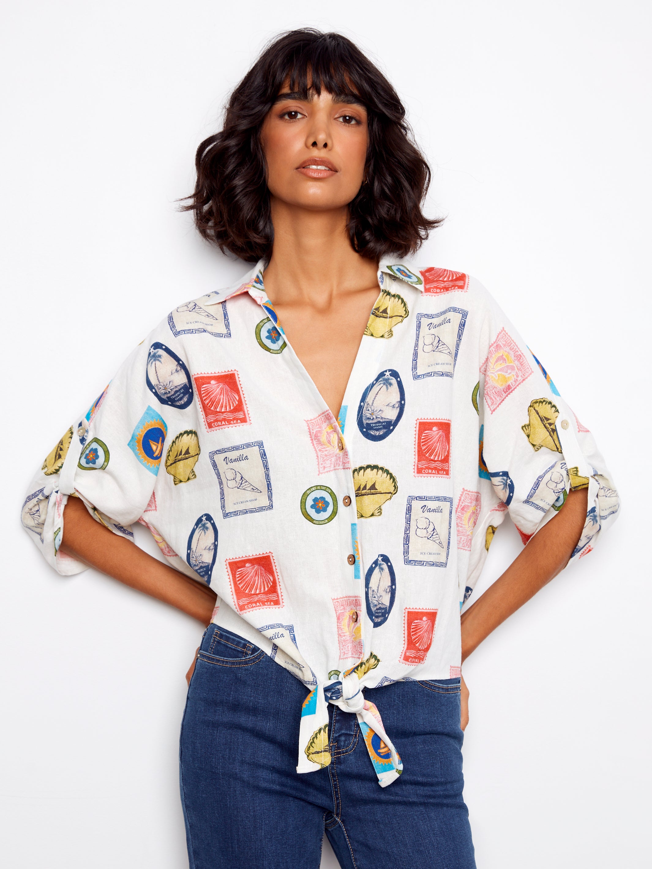 Woman wearing a colorful patterned shirt with rolled-up sleeves on a white background