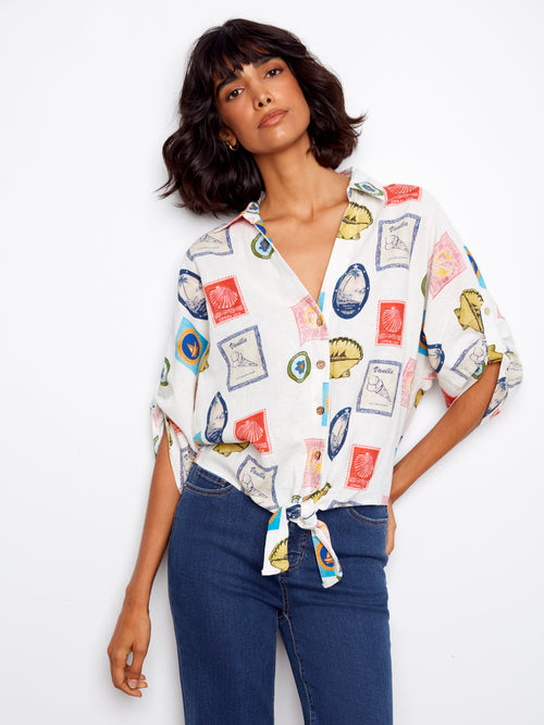 Woman wearing a colorful patterned shirt with a white background