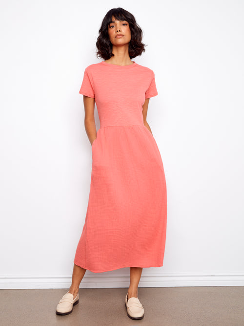 Woman wearing a coral dress against a white background