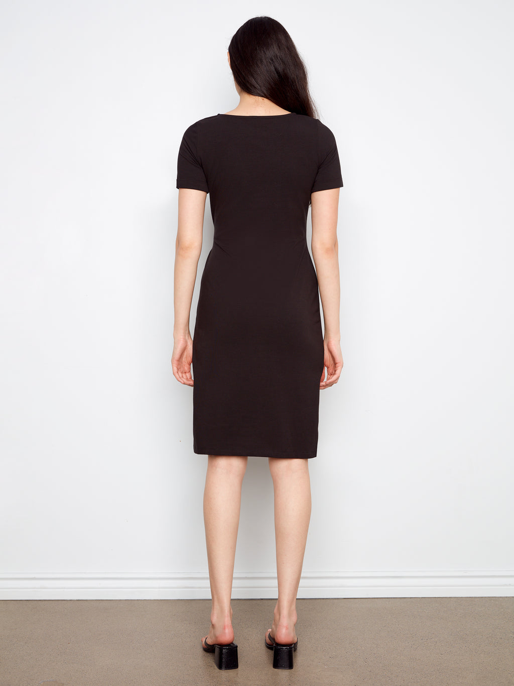 Person wearing a black dress against a white background