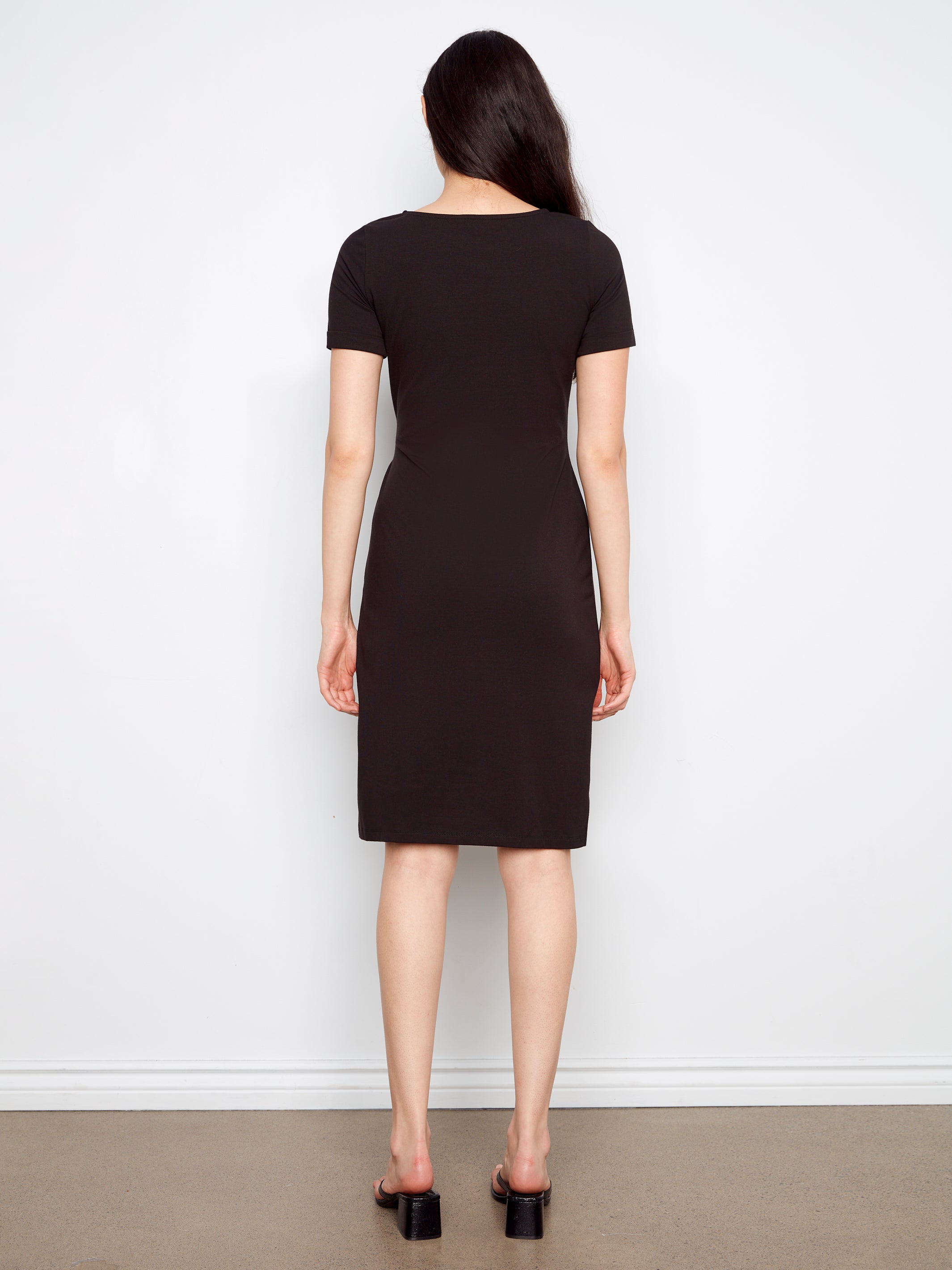 Person wearing a black dress against a white background