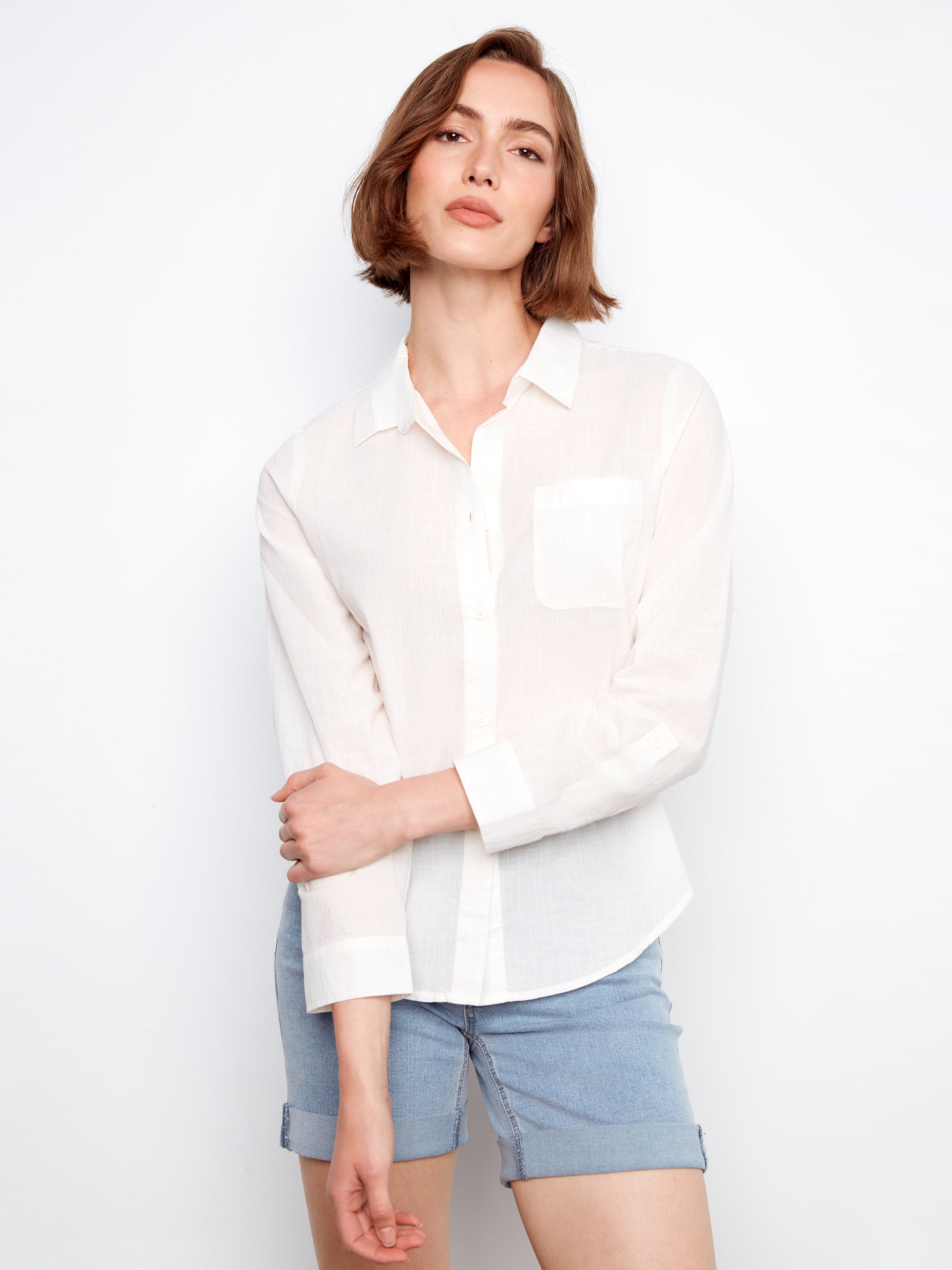 Woman wearing a white shirt and light blue shorts on a white background