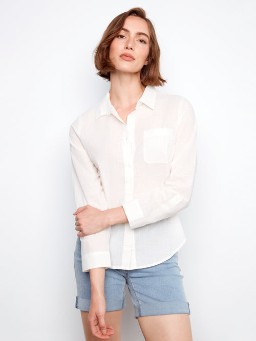 Woman wearing a white shirt and light blue shorts on a white background