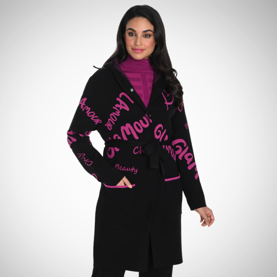Jaboli Boutique - Fergus Ontario - Frank Lyman - Coatigan. Luxurious cardigan/coat Elevated comfort and stylish design Cozy knit fabric Black and magenta script pattern Hooded Snap closure Belted waist Composition: 48% rayon, 21% nylon, 26% polyester, 5% spandex Perfect for Fall/Winter wardrobe Pairs well with Frank Lyman Faux Leather Leggings