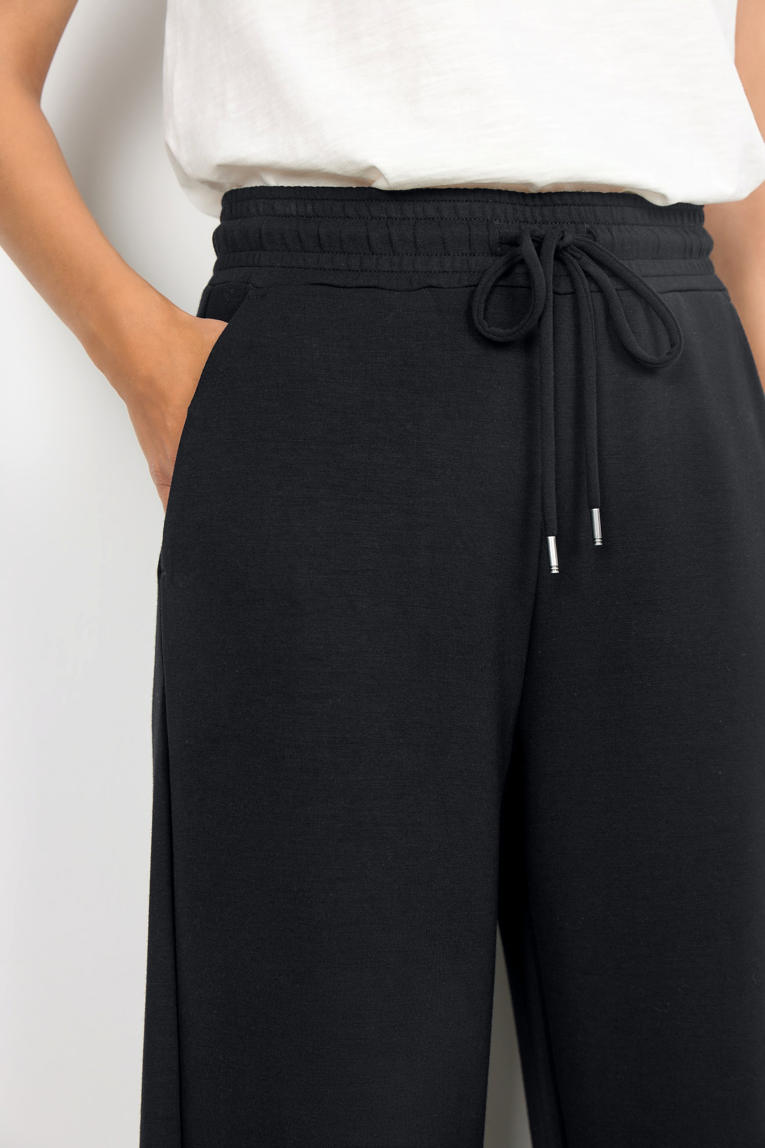 Black wide-leg pants with a drawstring waist on a white background
