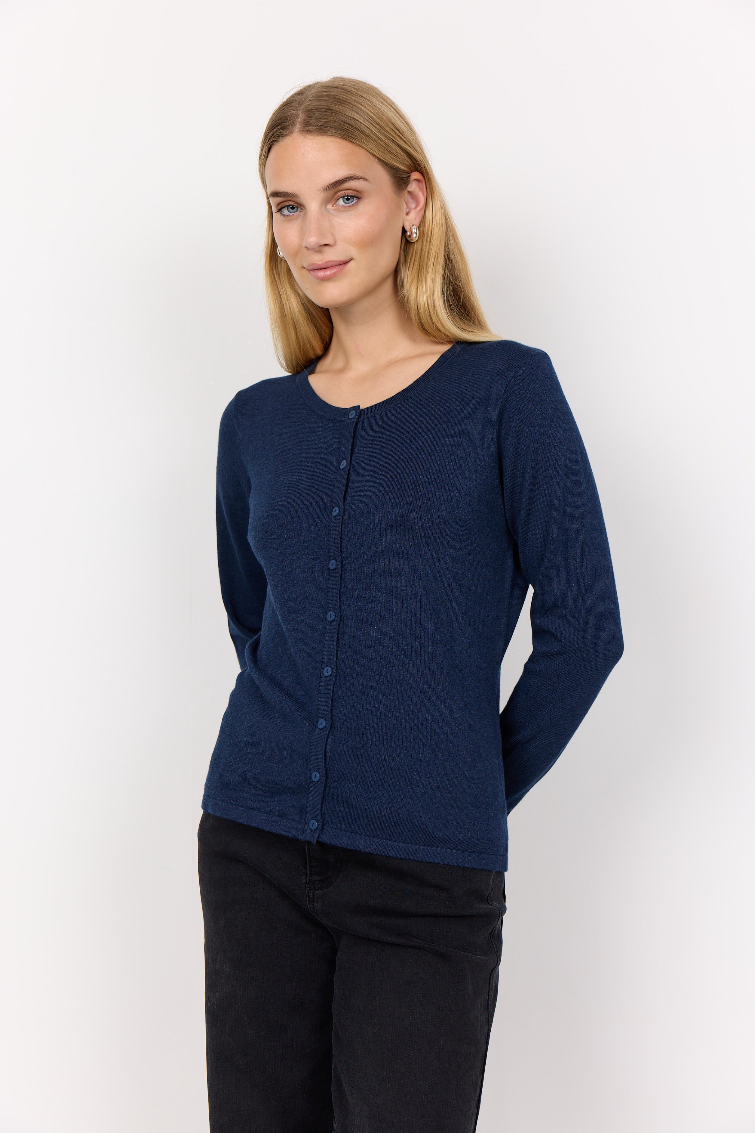 Woman wearing a navy blue cardigan against a white background