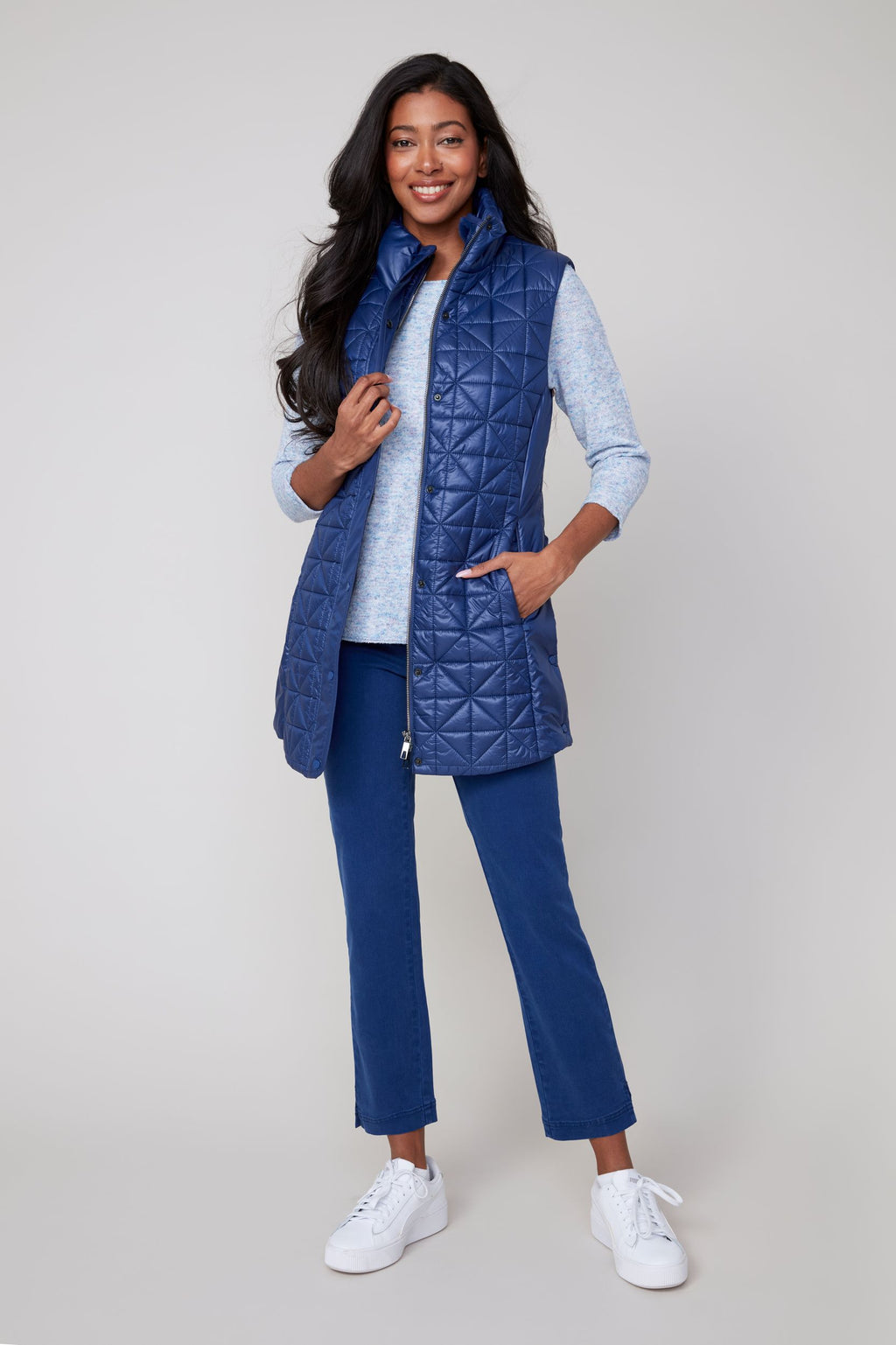 Jaboli Boutique|Fergus Ontario|Renuar| Luxe Long Quilted Vest| colour oxford blue. women’s long quilted vest in Oyster, Oxford Blue, and Porto (Merlot) colours. Features a cozy stand-up collar trimmed with luxe faux fur, a zip and snap front closure for secure layering, and side snaps at the hips for added mobility. The vest has a sleek, slim fit with a 31-inch mid-thigh length, designed as a stylish outerwear piece for fall and winter. Perfect for layering over sweaters and casual chic outfits.