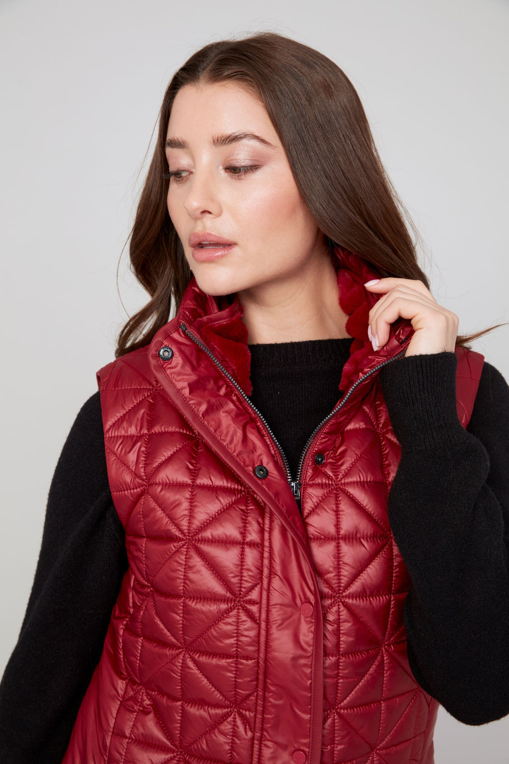 Jaboli Boutique|Fergus Ontario|Renuar| Luxe Long Quilted Vest| colour Porto. women’s long quilted vest in Oyster, Oxford Blue, and Porto (Merlot) colours. Features a cozy stand-up collar trimmed with luxe faux fur, a zip and snap front closure for secure layering, and side snaps at the hips for added mobility. The vest has a sleek, slim fit with a 31-inch mid-thigh length, designed as a stylish outerwear piece for fall and winter. Perfect for layering over sweaters and casual chic outfits.