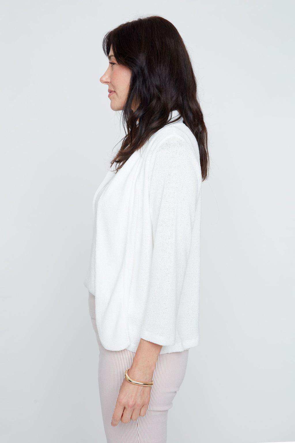 Woman wearing a white blouse against a plain background