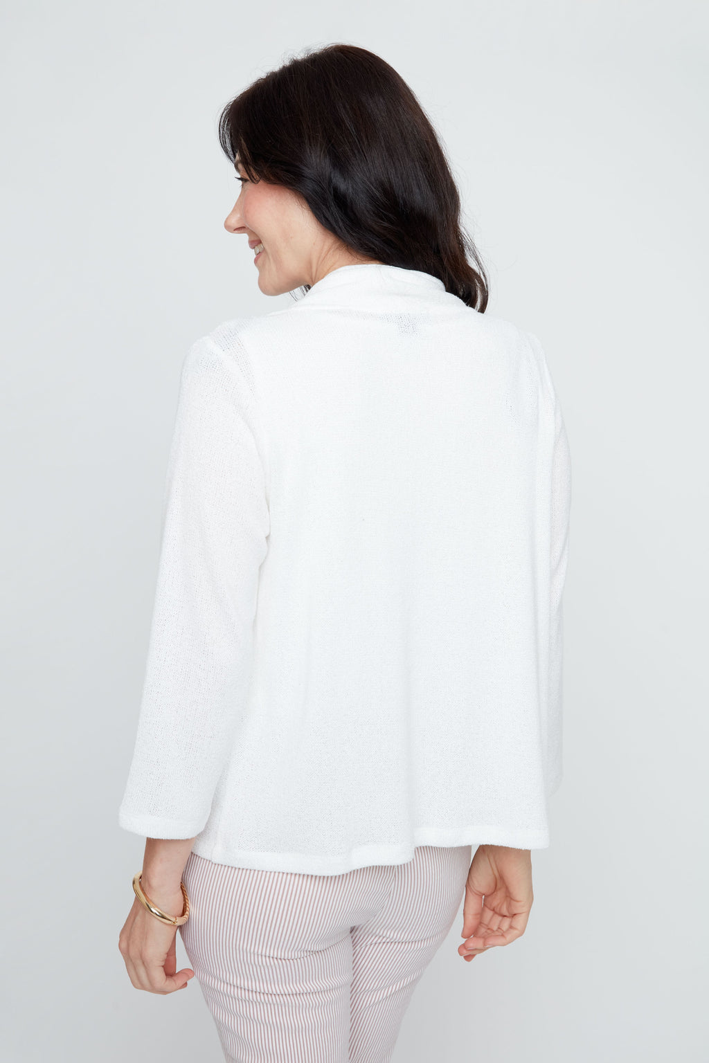 Woman wearing a white blazer against a plain background