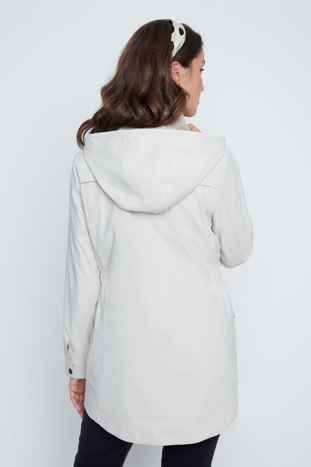 Person wearing a light gray hooded coat on a white background