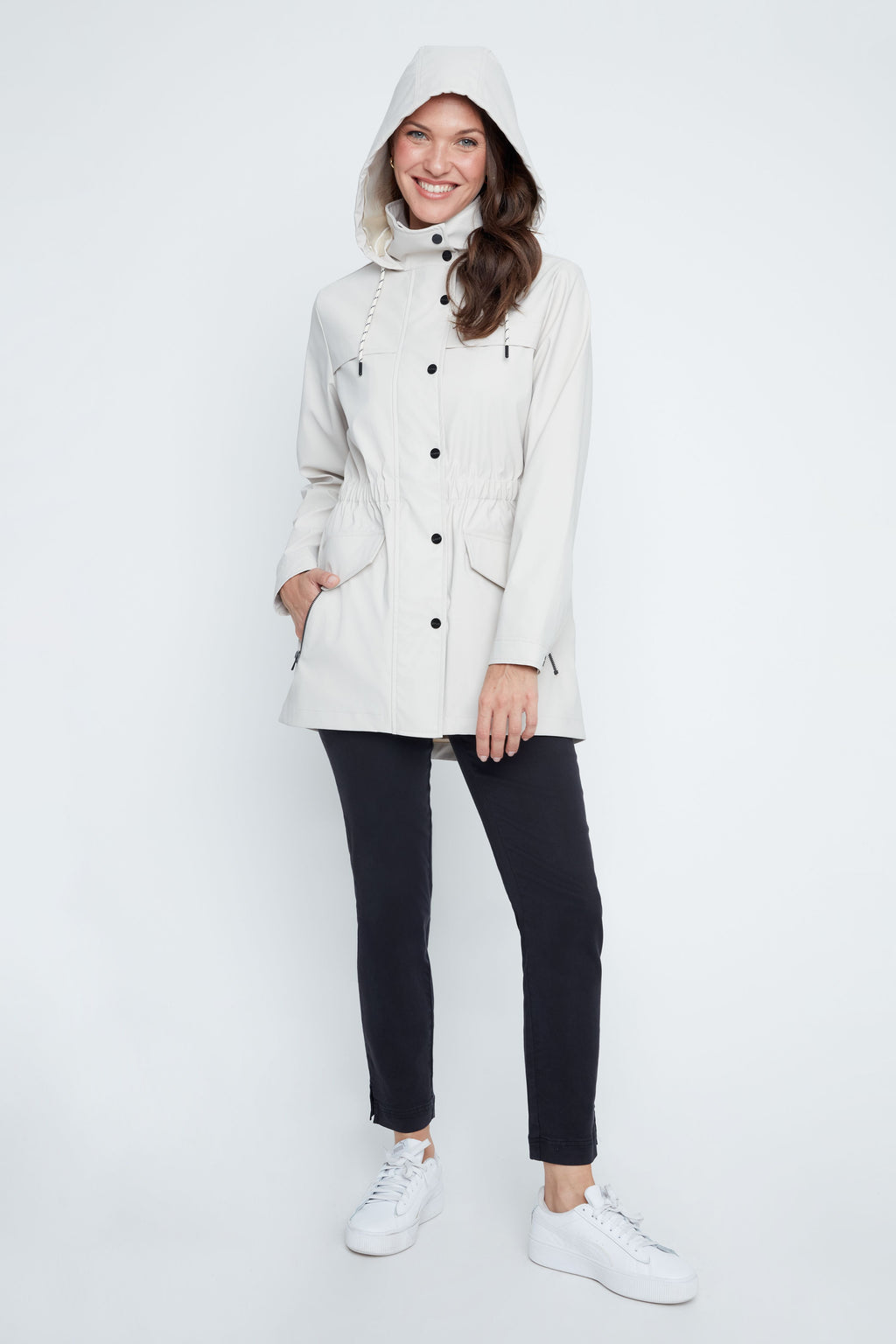 Woman wearing a white coat with a hood on a white background
