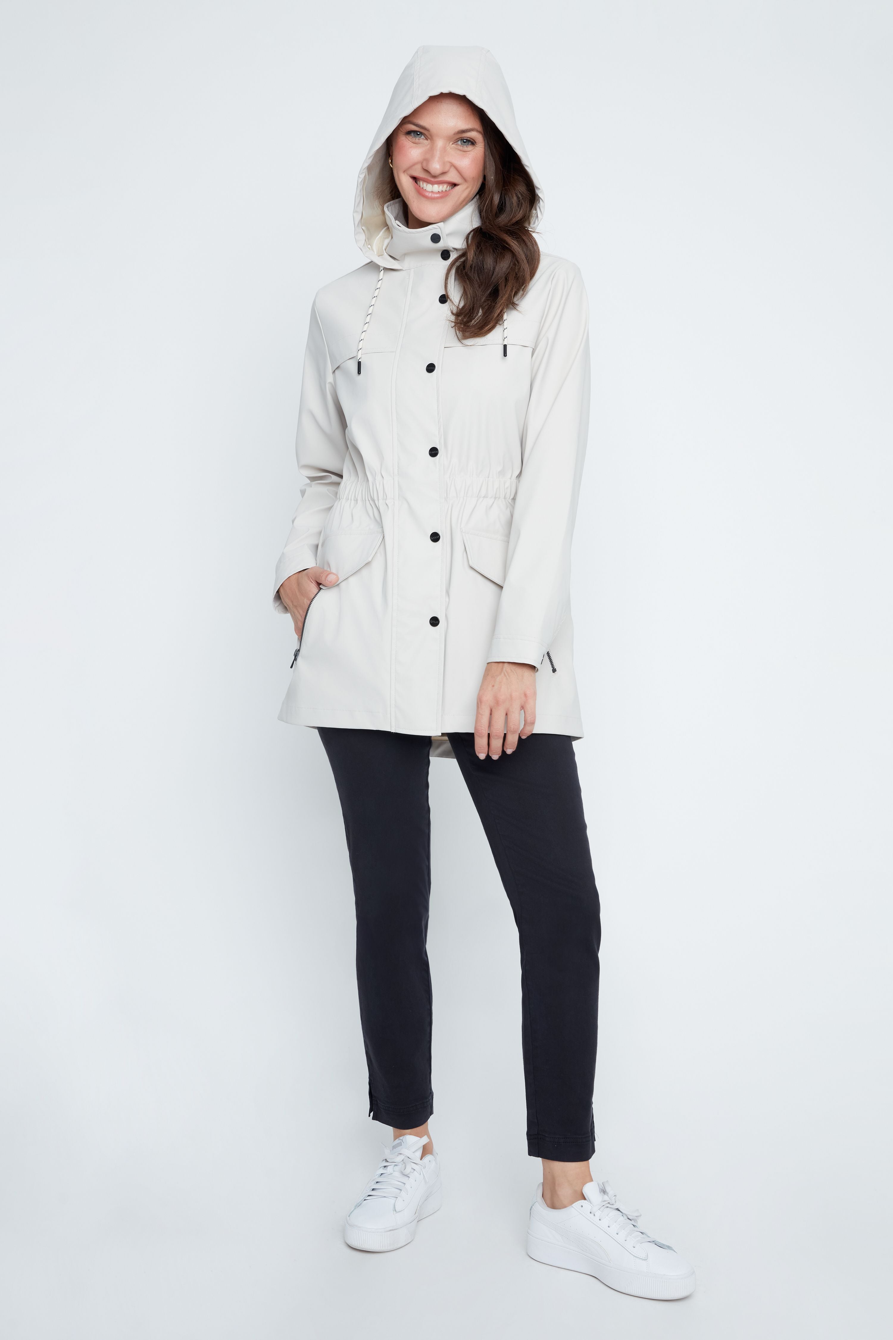 Woman wearing a white coat with a hood on a white background
