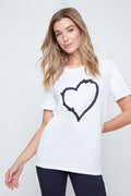 Woman wearing a white t-shirt with a black heart design on a plain background