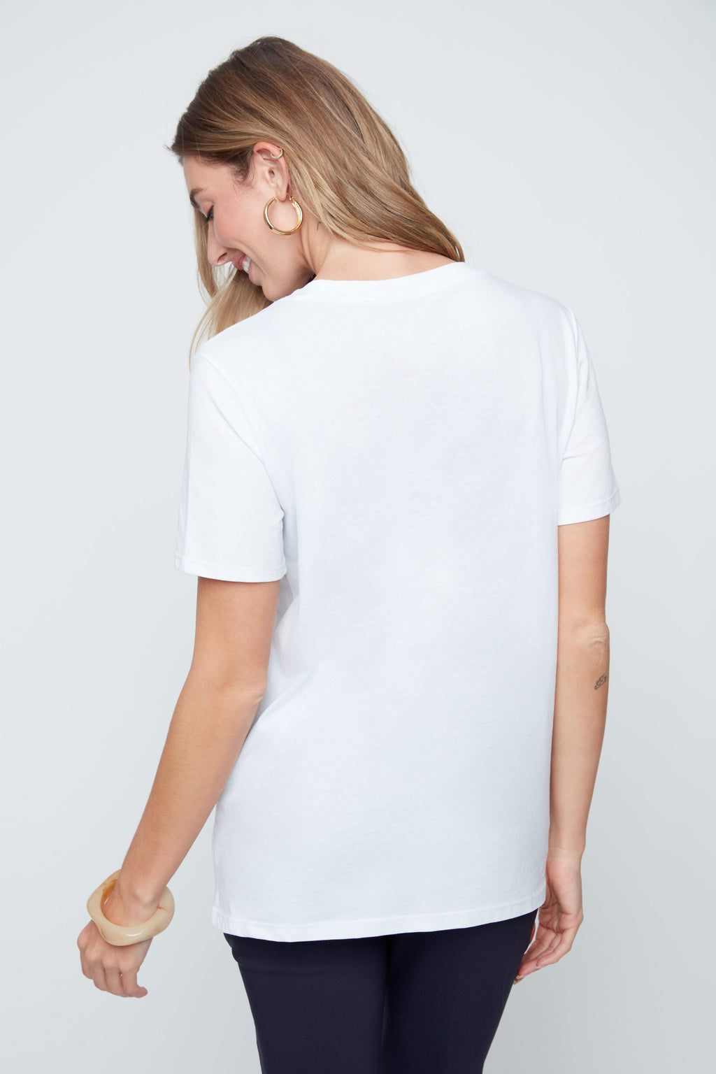 Woman wearing a white t-shirt on a plain background