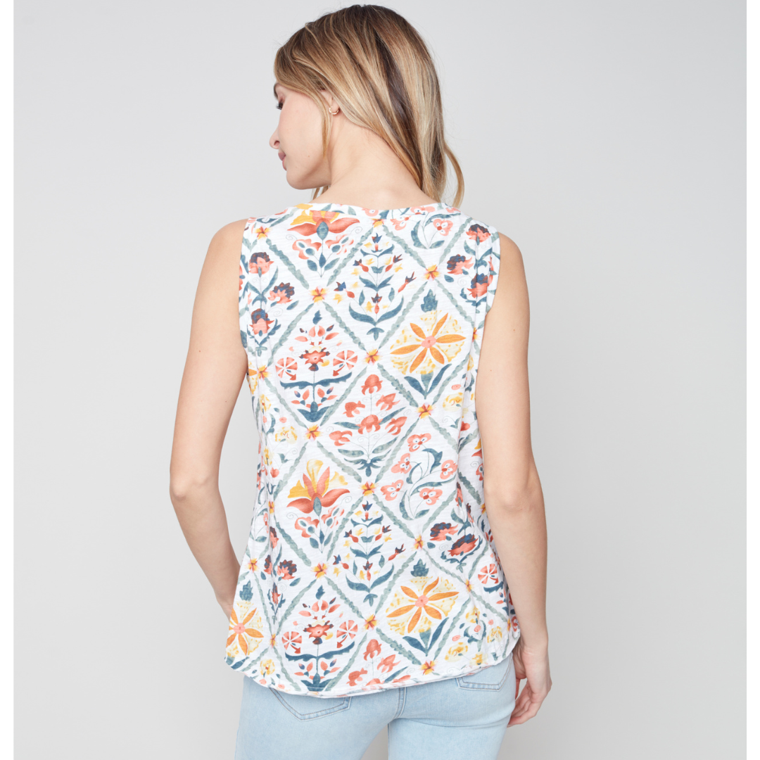 Jaboli Boutique - Fergus Ontario - Charlie B - Printed Sleeveless Top. Multi Coloured Tile Print Tank Top Round Neckline Colours Consist Of Orange, Yellow, Sage Green, And Dusty Blue Floral Print On A White Base. Wear This Tank Top With The Charlie B Essential White Linen Jacket For A Fresh Summer Look.